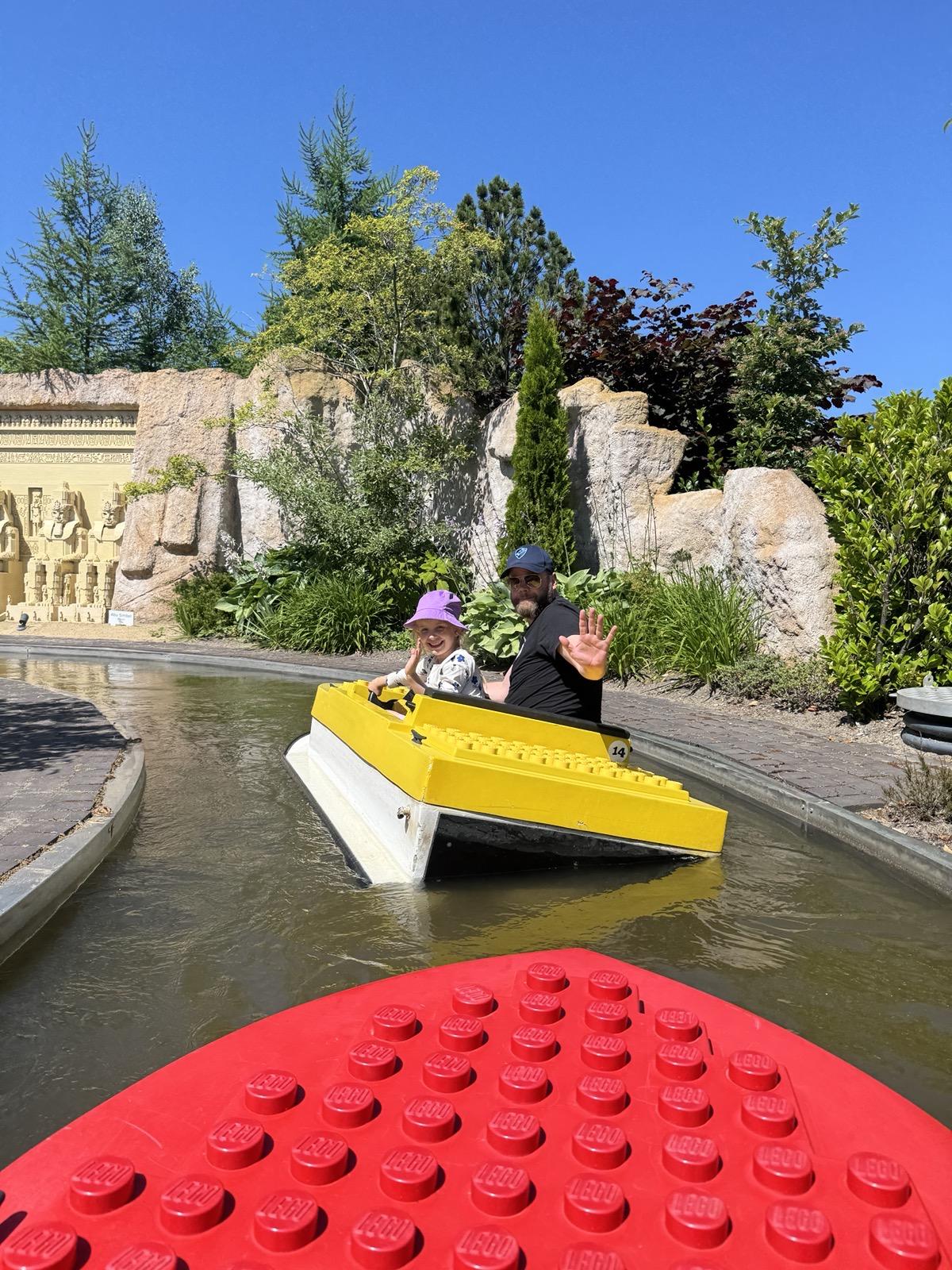 Me sitting with my daughter in boat at Legoland, Denmark. The boat is leaning heavily to the side I’m sitting at.